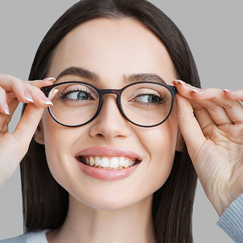 Woman putting eyeglasses on her face